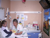 Une enfant et une infirmière regarde un livre ensemble