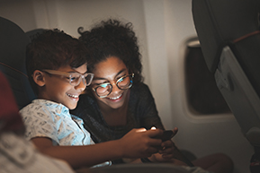 enfant et sa mère qui regarde un écran lors d'un voyage en avion