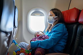 enfant endormi dans les bras de sa mère lors d'un vol  en avion