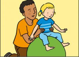 Un ergothérapeute maintient une petite fille assise en équilibre sur un gros ballon