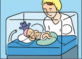 Un bébé prématuré couché dans une couveuse avec sa maman à ses côtés